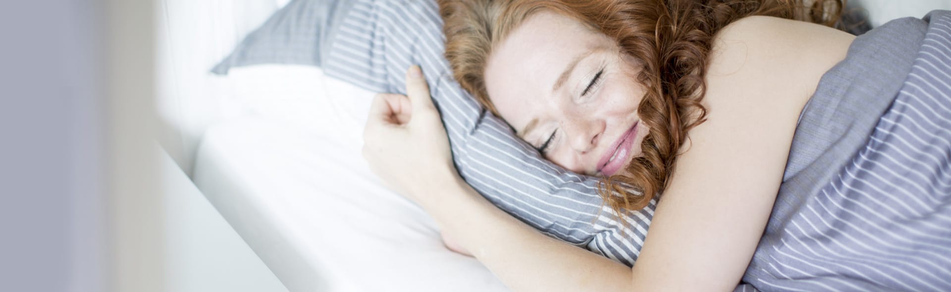 Frau liegt glücklich im Bett